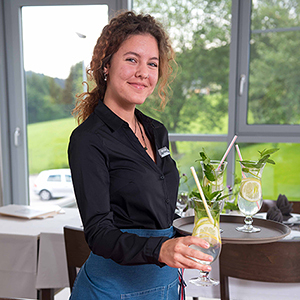 Schülerin serviert Cocktail im Restaurant